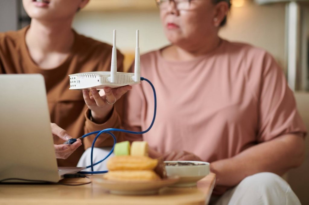 Grandchild Setting Up Router Settings for Grandmother